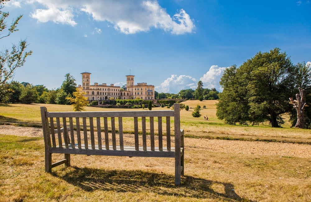 bench on a sunny day with Osborne house in the back ground 