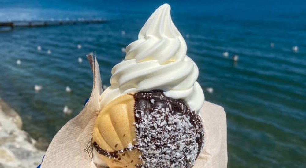 a soft serve ice cream with the sea in the background