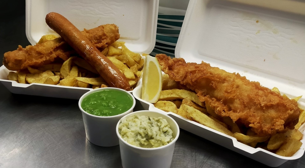 sausage, battered sausage, and battered fish with chips and mushy peas